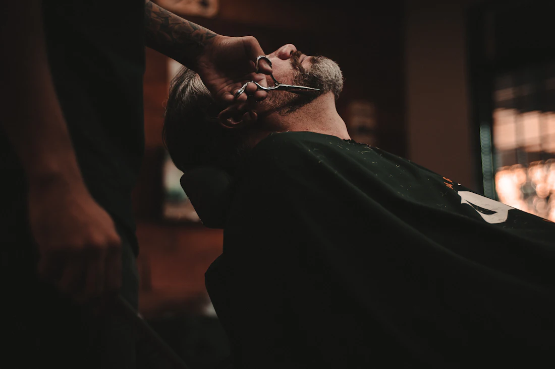 Zákazník v kresle — úprava brady britvou v Barber Shop MF Kežmarok
